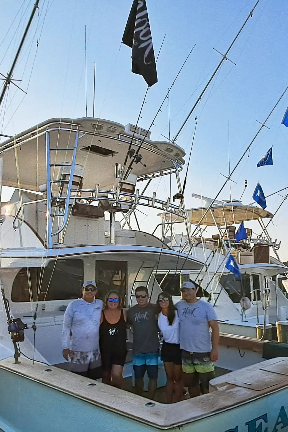 The family behind the brand, Group of people on a boat with a clear blue sky wearing Hook Optics Sunglasses