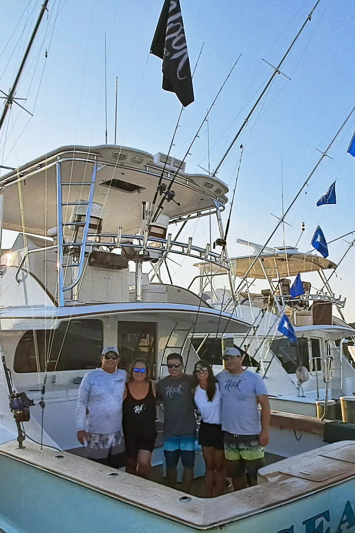 The family behind the brand, Group of people on a boat with a clear blue sky wearing Hook Optics Sunglasses